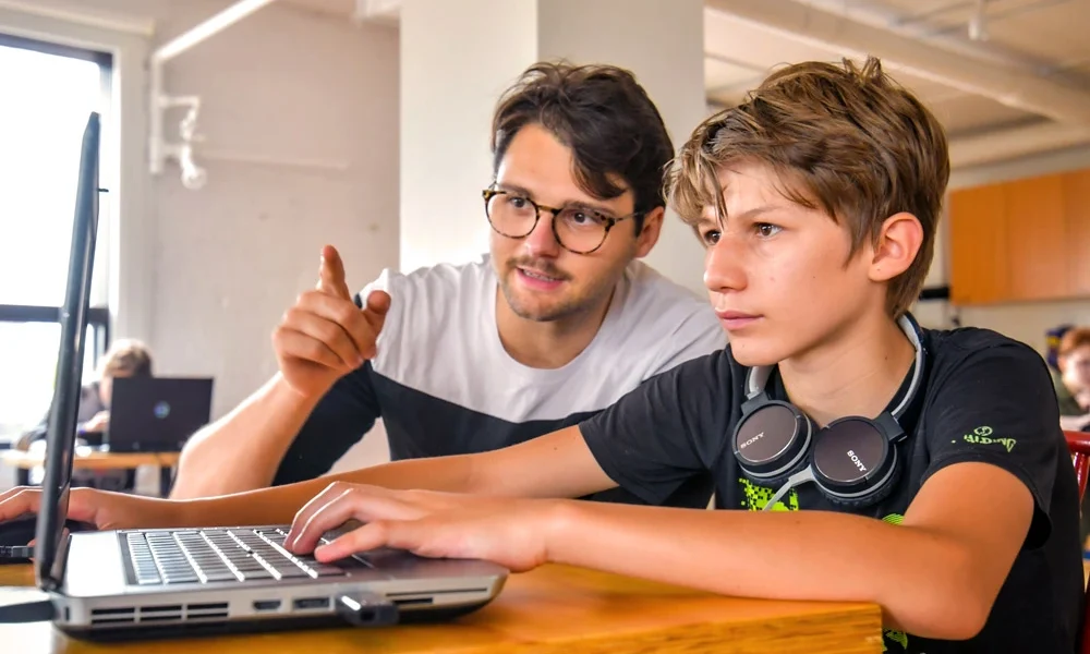 Un professeur et son élève programmant du code informatique