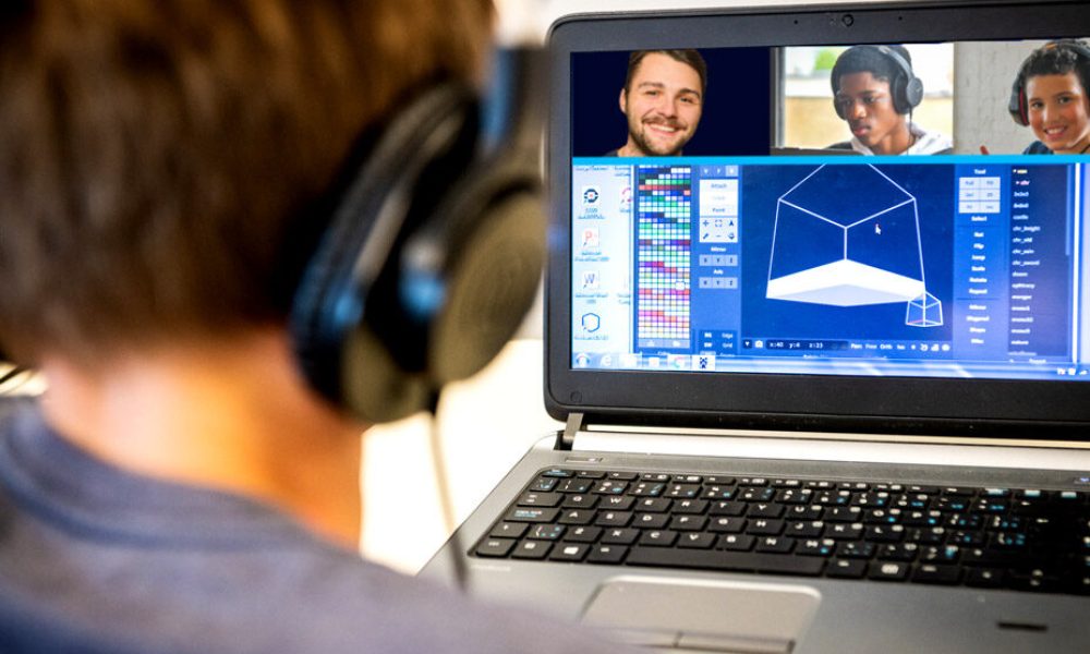 Un jeune devant son ordinateur suivant un cours en ligne