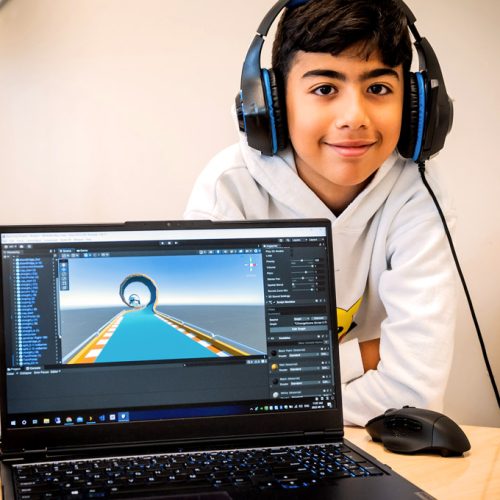 Un enfant présentant son jeu vidéo sur son ordinateur